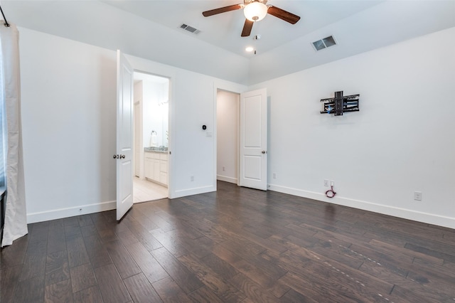 unfurnished bedroom with dark wood-style floors, visible vents, and baseboards