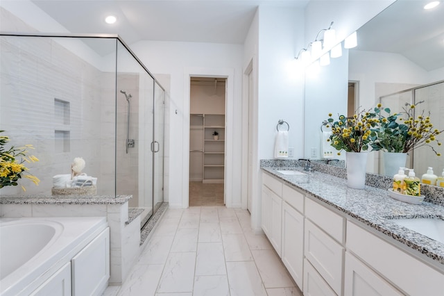 full bathroom with a sink, marble finish floor, a spacious closet, double vanity, and a stall shower