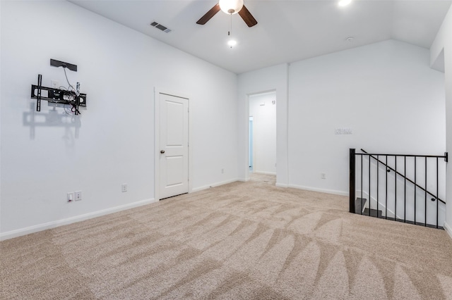 spare room featuring baseboards, visible vents, lofted ceiling, ceiling fan, and carpet floors