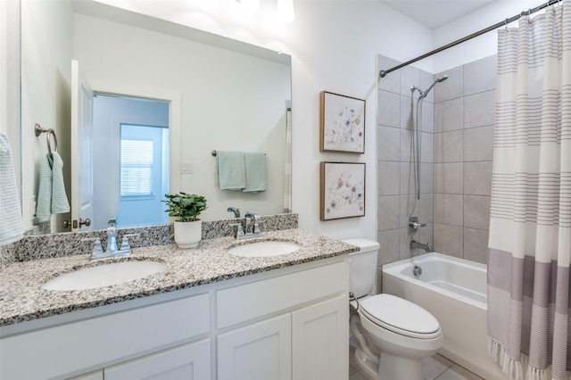 bathroom with double vanity, shower / tub combo, a sink, and toilet