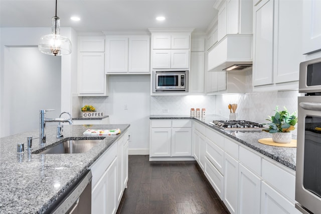 kitchen with custom range hood, dark wood-style flooring, stainless steel appliances, white cabinetry, and a sink