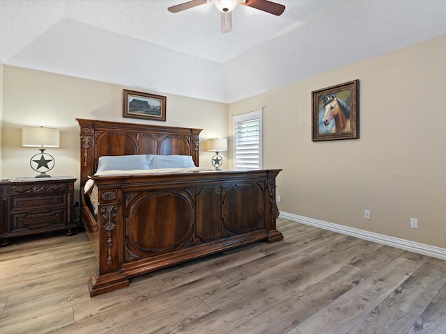 bedroom featuring vaulted ceiling, ceiling fan, light wood-style flooring, and baseboards