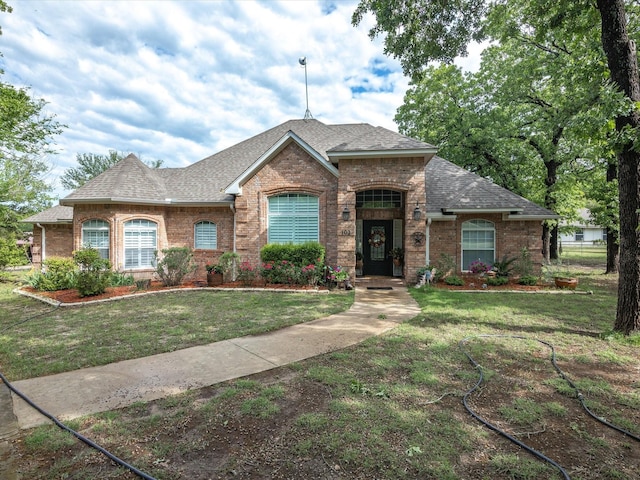 102 W Ridge St, Decatur, TX 76234 - view of front of home featuring brick siding, a front yard, and roof with shingles