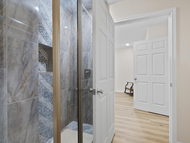 bathroom featuring a shower stall and wood finished floors