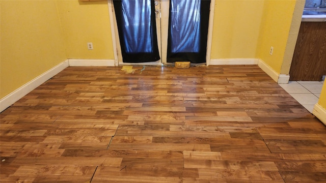 spare room with wood finished floors and baseboards