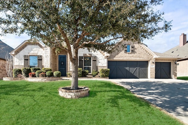 view of front of house featuring a front yard, brick siding, driveway, and an attached garage