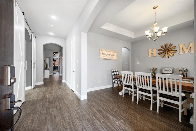 dining space featuring a chandelier, arched walkways, dark wood-style flooring, and baseboards