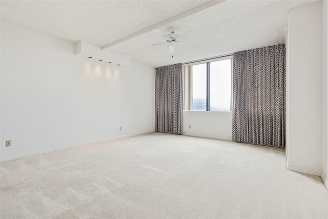 spare room with a textured ceiling, ceiling fan, light carpet, and baseboards