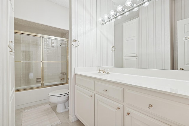 full bath featuring enclosed tub / shower combo, vanity, tile patterned flooring, and toilet