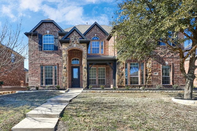 traditional-style home featuring a front yard and brick siding