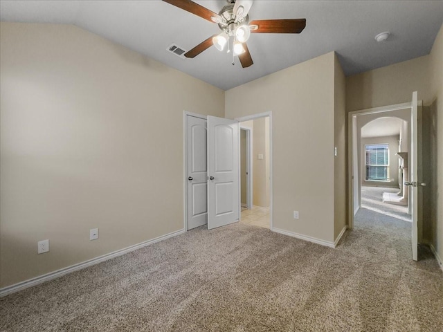 unfurnished bedroom with light carpet, baseboards, visible vents, ceiling fan, and vaulted ceiling