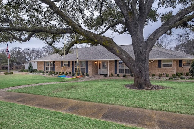 ranch-style house with a front lawn, a shingled roof, and brick siding