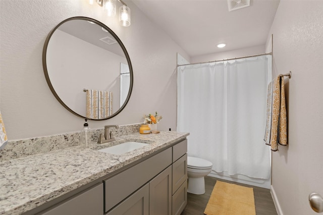 full bathroom with toilet, visible vents, wood finished floors, and vanity