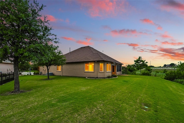 10112 Parkcrest Ct, Denton, TX 76207 - back of house at dusk featuring a shingled roof, fence, and a yard