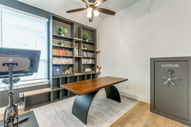 office space featuring light wood-style floors, ceiling fan, baseboards, and vaulted ceiling