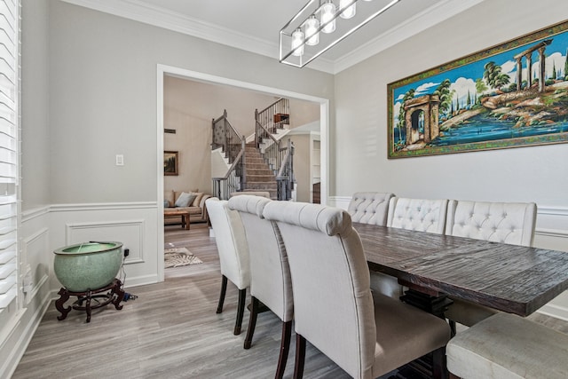 5505 Lomita Cir, Plano, TX 75023 - dining room featuring stairs, crown molding, light wood-type flooring, a chandelier, and a wainscoted wall