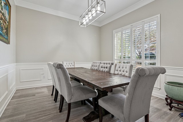 5505 Lomita Cir, Plano, TX 75023 - dining area featuring a decorative wall, ornamental molding, wood finished floors, a chandelier, and wainscoting