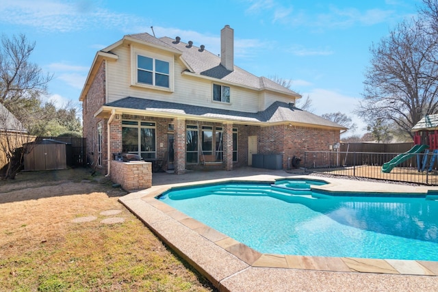 5505 Lomita Cir, Plano, TX 75023 - view of pool featuring a patio, a storage shed, a playground, an outdoor structure, and a pool with connected hot tub