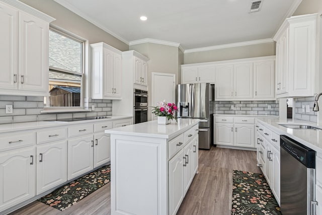 5505 Lomita Cir, Plano, TX 75023 - kitchen featuring appliances with stainless steel finishes, a sink, decorative backsplash, white cabinets, and ornamental molding
