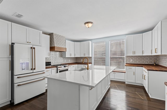 kitchen featuring a sink, visible vents, high quality appliances, custom exhaust hood, and dark wood-style floors