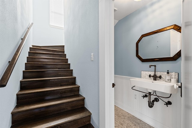 staircase with wainscoting and tile patterned floors