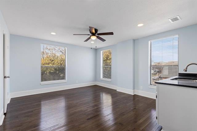 interior space with recessed lighting, a sink, visible vents, baseboards, and dark wood finished floors