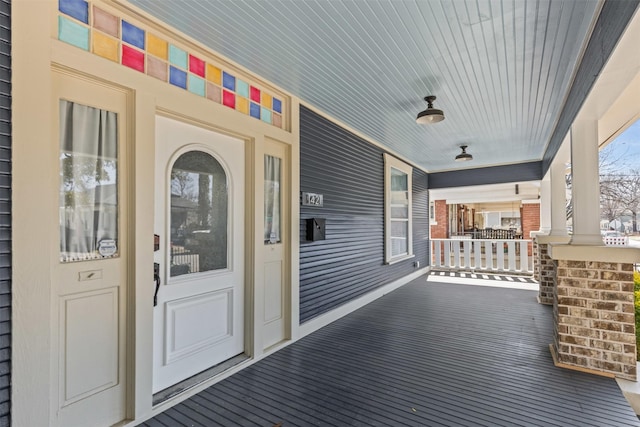 view of exterior entry featuring covered porch