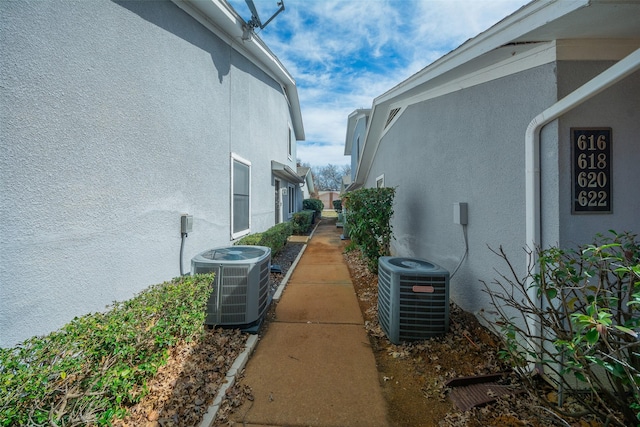 view of side of property with central AC and stucco siding