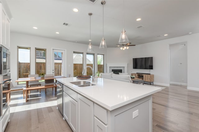 kitchen featuring a fireplace, stainless steel appliances, recessed lighting, visible vents, and a sink