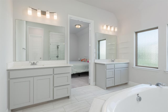 full bathroom with two vanities, a sink, a tile shower, and a bath