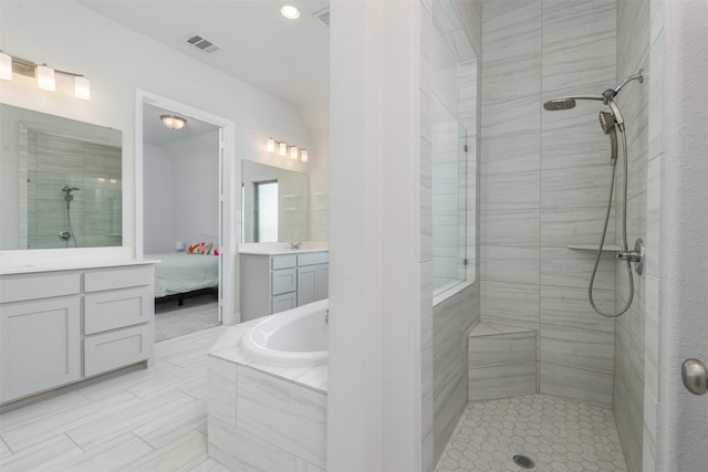 ensuite bathroom with ensuite bath, visible vents, tiled shower, and vanity