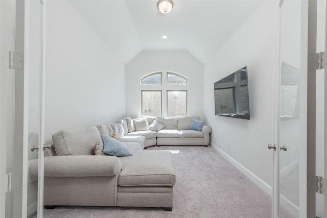 carpeted living area featuring baseboards and vaulted ceiling