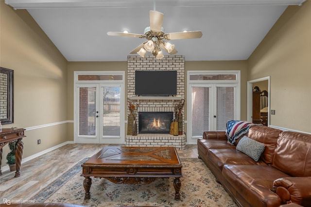 living area with vaulted ceiling, french doors, and a ceiling fan