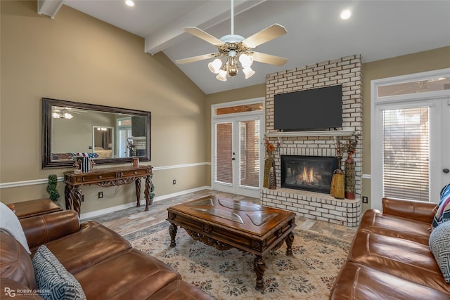 living area with baseboards, a ceiling fan, vaulted ceiling with beams, french doors, and a fireplace