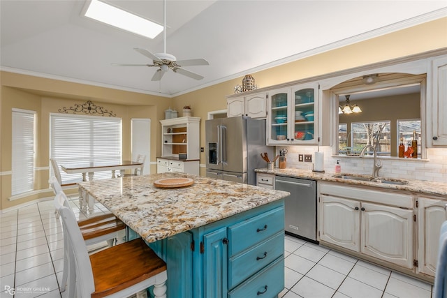 kitchen with stainless steel appliances, a breakfast bar, a sink, a center island, and crown molding