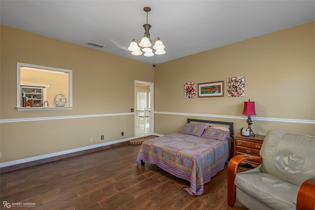 bedroom featuring baseboards, visible vents, an inviting chandelier, and wood finished floors