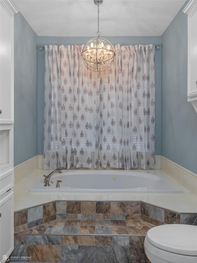 full bathroom featuring a chandelier, toilet, and a bath