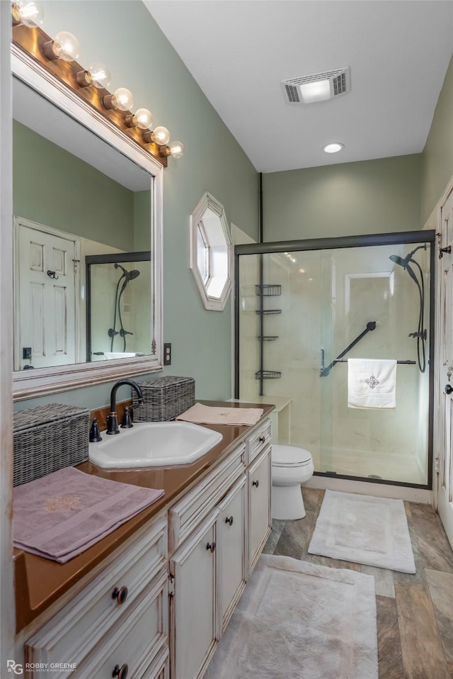 full bathroom with visible vents, toilet, a shower stall, and vanity