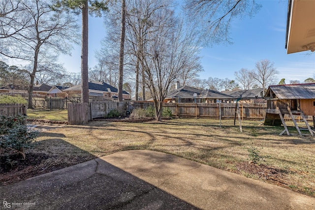 view of yard with a fenced backyard, a residential view, a playground, and a patio