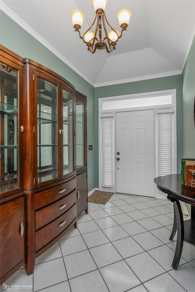 entrance foyer with ornamental molding, lofted ceiling, and an inviting chandelier