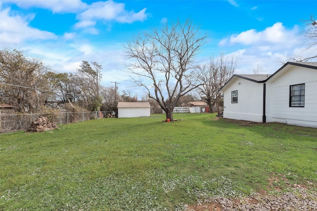 view of yard with a fenced backyard, a shed, and an outdoor structure