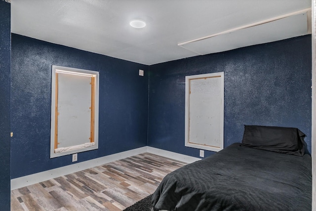 bedroom featuring baseboards and wood finished floors