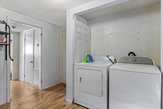 laundry room featuring washer and dryer, visible vents, light wood-type flooring, laundry area, and baseboards