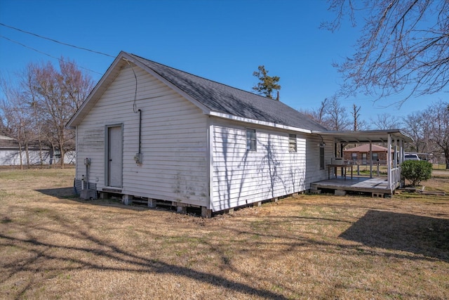 view of home's exterior featuring a yard and a shingled roof