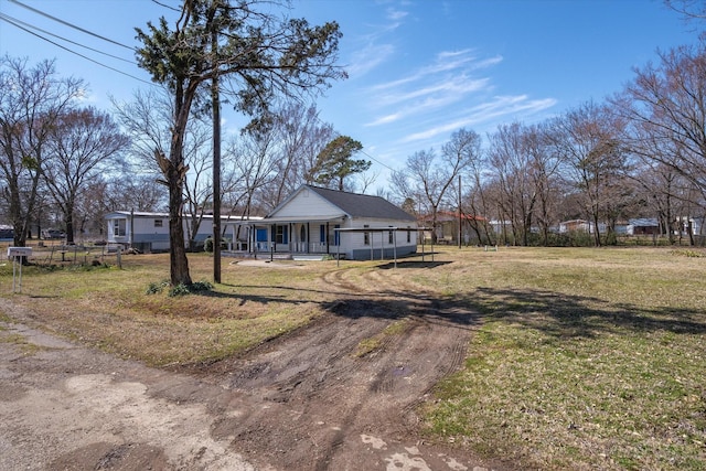 view of front of house with a porch, a front yard, driveway, and fence