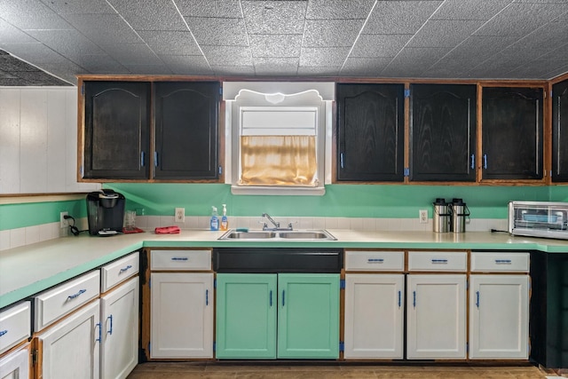 kitchen featuring a toaster, light countertops, and a sink