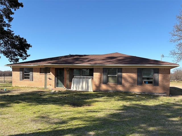 ranch-style home with a front yard and brick siding