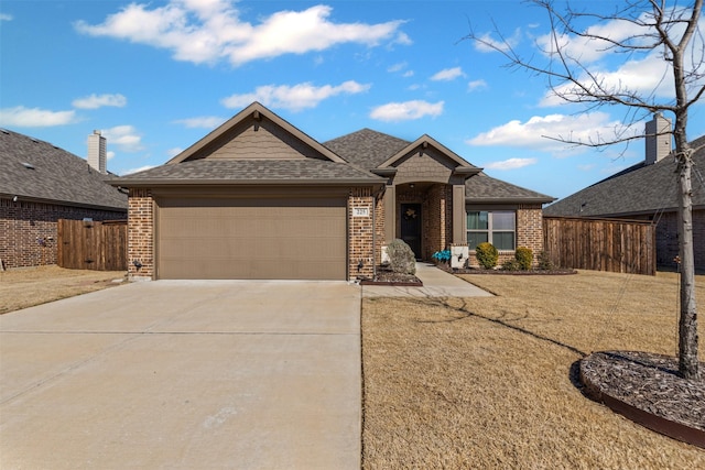 single story home featuring driveway, brick siding, an attached garage, and fence