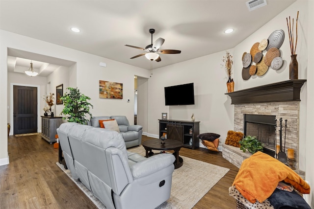 living area featuring recessed lighting, visible vents, ceiling fan, a stone fireplace, and wood finished floors