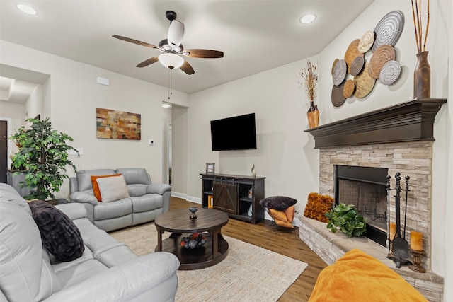 living room with ceiling fan, a fireplace, wood finished floors, and recessed lighting